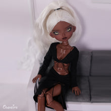 Afrobarbie Signature - Poupée noire Amara- assise sur un banc